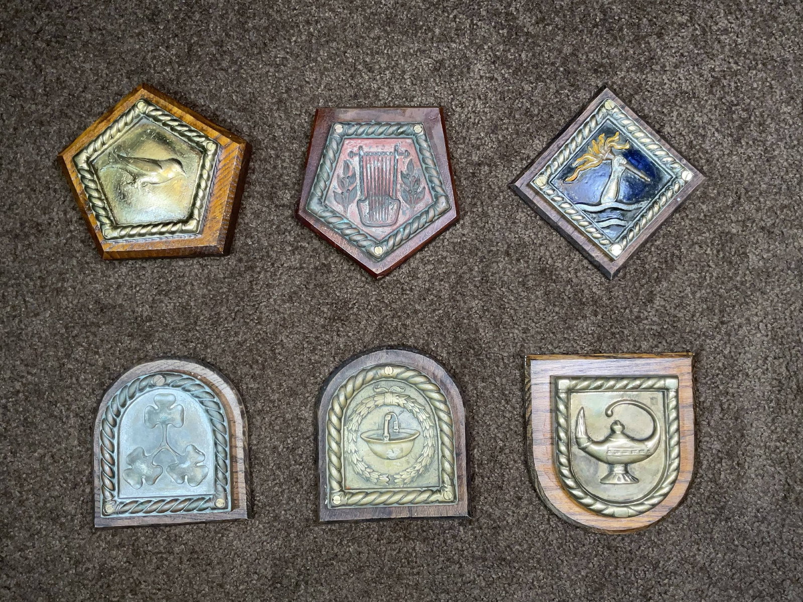 Royal Navy Chatham Dockyard Pattern Ship's Badges from Six Warships: Cast bronze ship's badges from Royal Navy warships: HMS Sussex, HMS Flanders, HMS Shamrock, HMS Verity, HMS Somme, and HMS Calliope. All are mounted on wood plaques and are in pentagonal, shield, and 