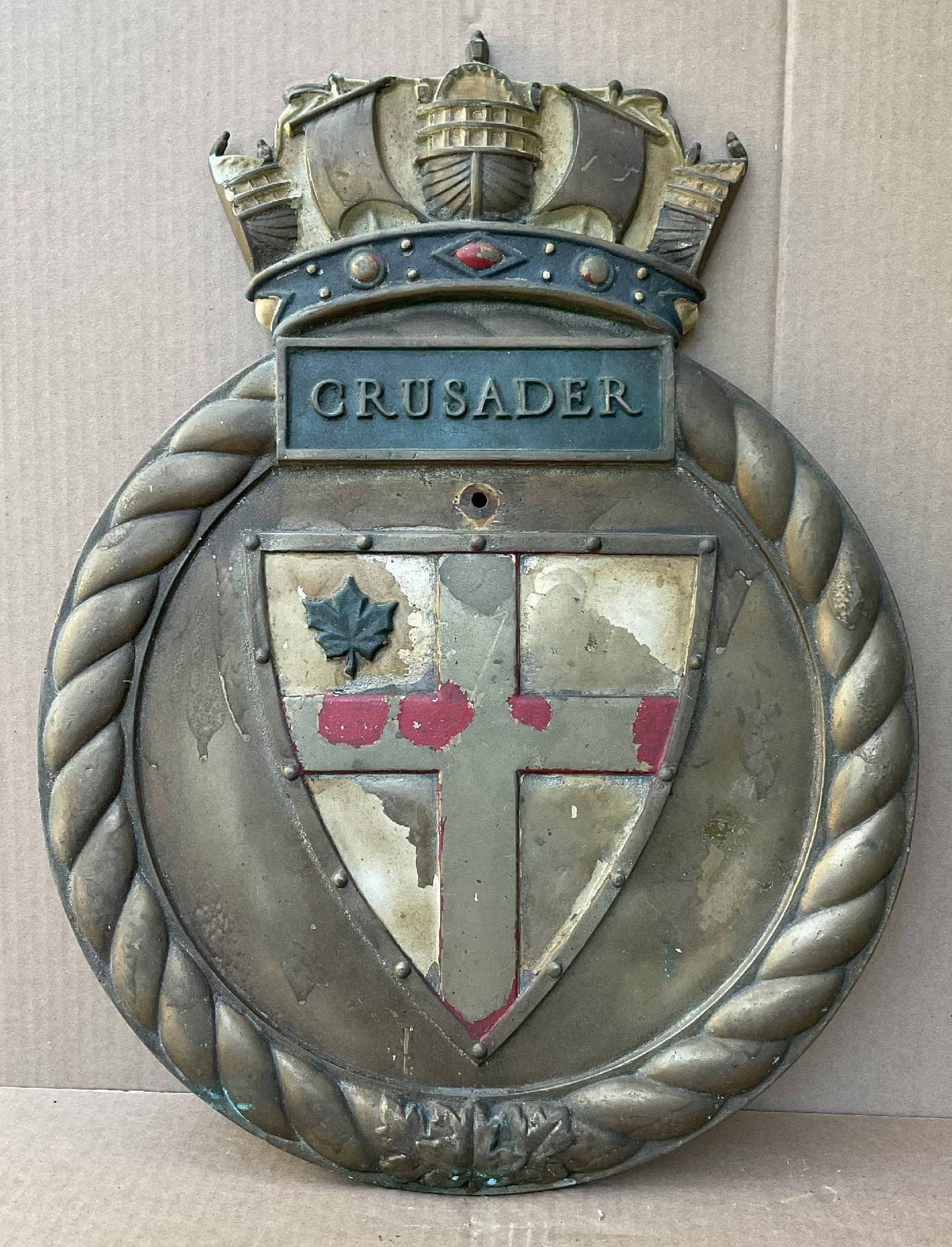 Royal Navy Screen Badge from the Destroyer HMS Crusader 1930: Royal Navy screen badge that is a two foot tall relic. Cast in brass. The flag is missing much of its paint. Naval crown at top with "Crusader" in the name panel. 32 lbs. 18" H x 23" W.