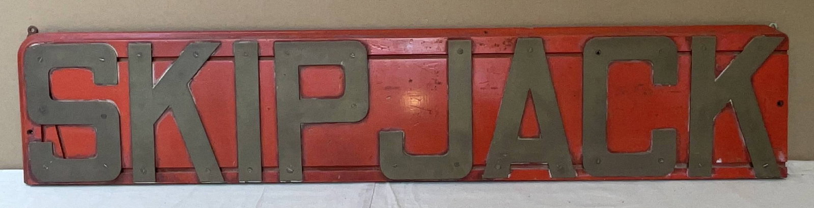 Royal Navy Ship's Nameboard from HMS Skipjack: Ship's nameboard from the Royal Navy warship HMS Skipjack. The wood backboard is mounted with heavy brass letters. 15 lbs. 10" H x 50" W. Showcasing bold lettering, the nameboard from Skipjack is a me