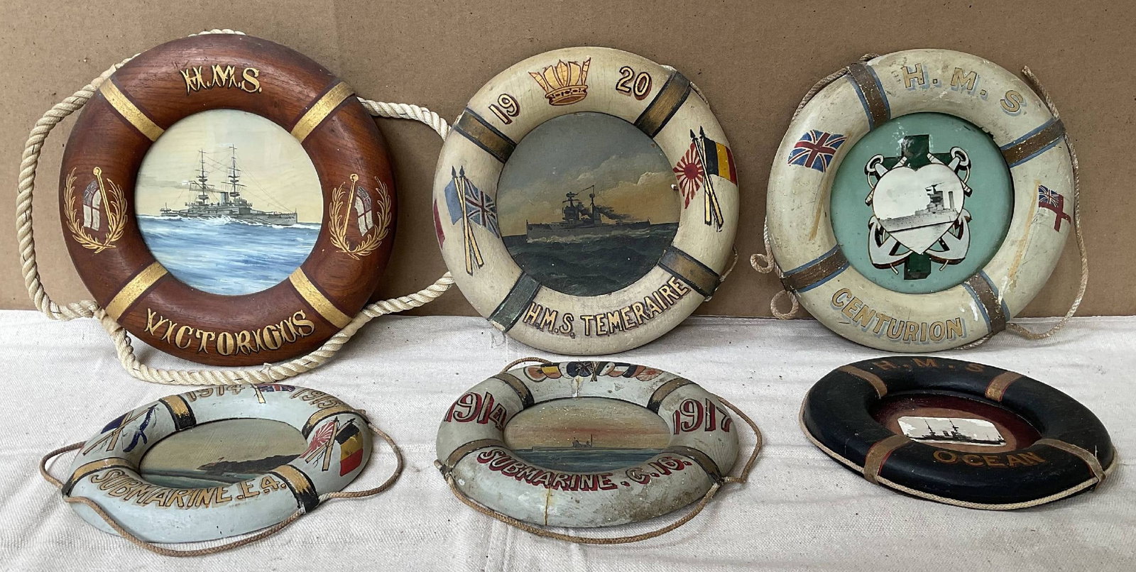 Six Period Miniature Liferings for Royal Navy Ships: Lot of six painted liferings with Royal Navy ship names and dates, with paintings and photos of ships in the center. Included are submarine E-4 (1914 & 1915), submarine C-16 (1914?1917), HMS Temeraire