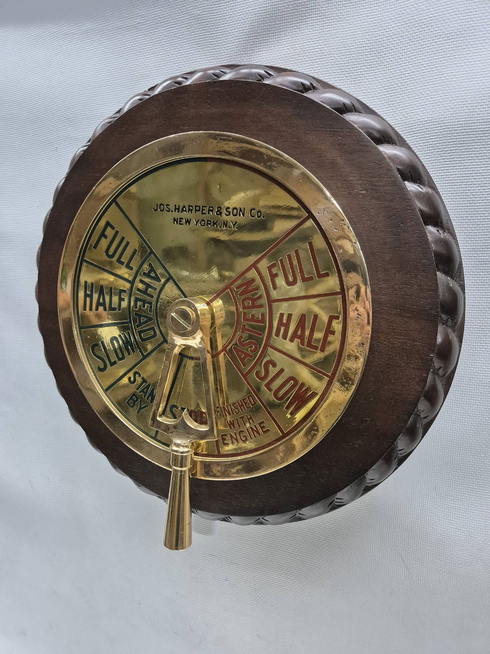Engine Order Telegraph Faceplate with Handle: Solid brass ship's telegraph face with bezel by Jos Harper and Son Co., New York. Meticulously polished and lacquered with ship's commands painted in red and black. Mounted to a wood backboard with