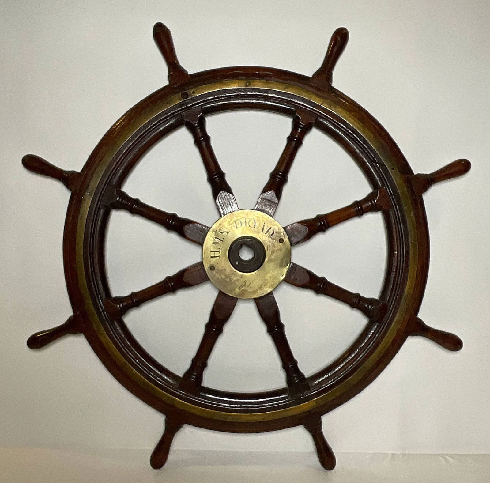 British Royal Navy Ship’s Wheel from HMS Dryad: Ship’s wheel with engraved brass hub cover “HMS Dryad.” Eight turned spindles and frame are varnished. HMS Dryad was a torpedo gunboat from 1893. Built at Chatham Dockyard. 50 lbs. 45"
