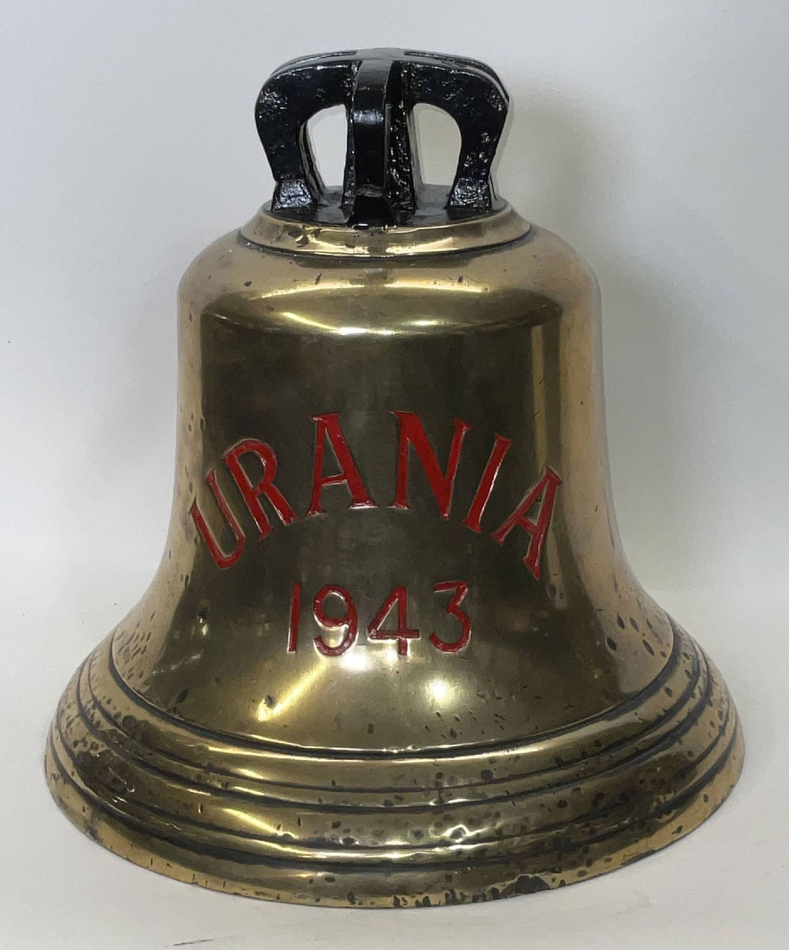 Bell from H.M.S. Urania, 1943: Solid brass bell from the ship H.M.S. Urania, engraved “Urania 1943” fitted with a six canon crown mount cast into the bell. H.M.S. Urania was a U?class destroyer of the British Royal Navy,