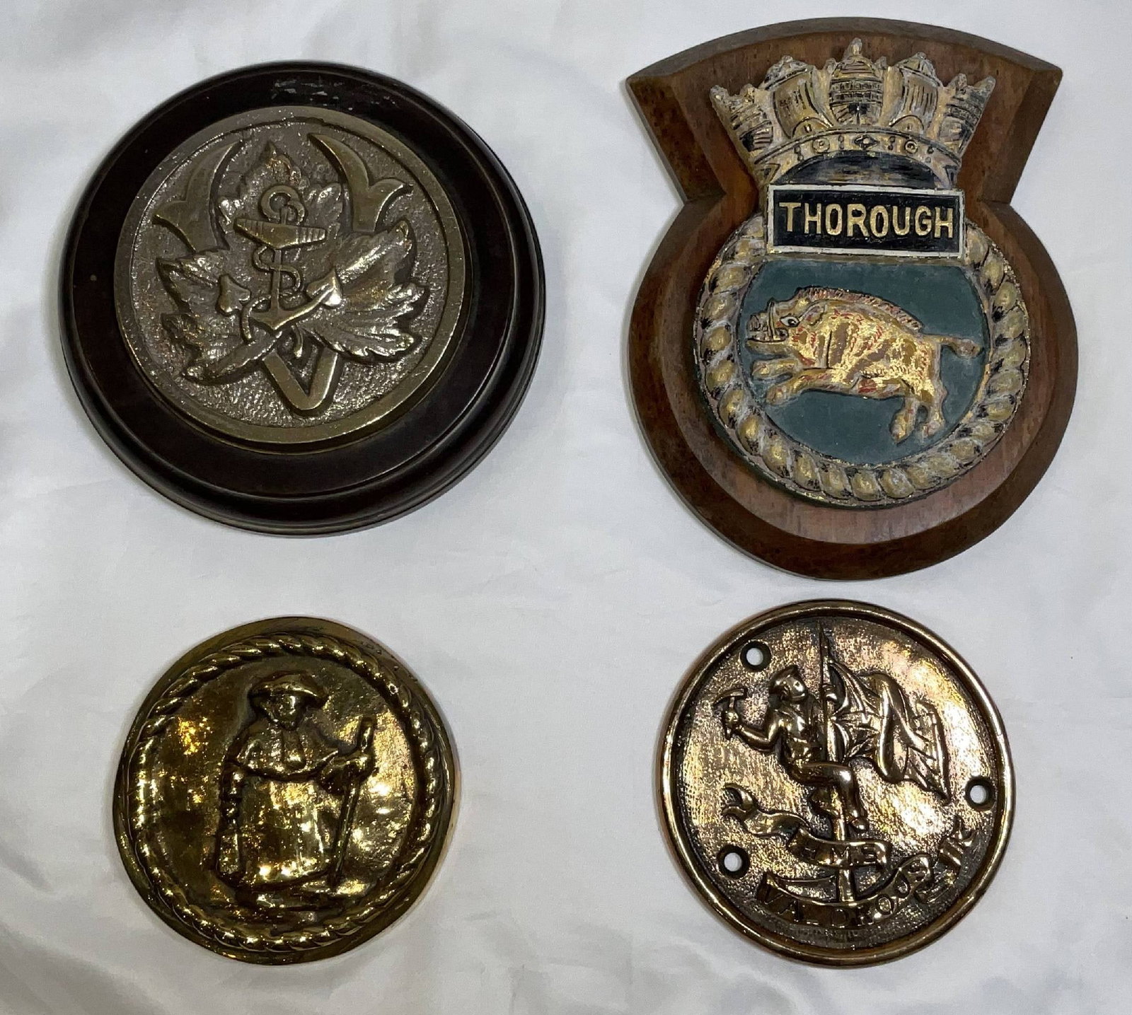 Ship's Gun Tompions and Badges from British Royal Navy Vessels: Cast brass gun tompions from Flower-class corvette HMS Vancouver, submarine HMS Thorough of 1943, anti-aircraft escort HMS Valorous, and one other. 4 ship's badges. 13 lbs. 9"H x 7"W large. 5"Diameter