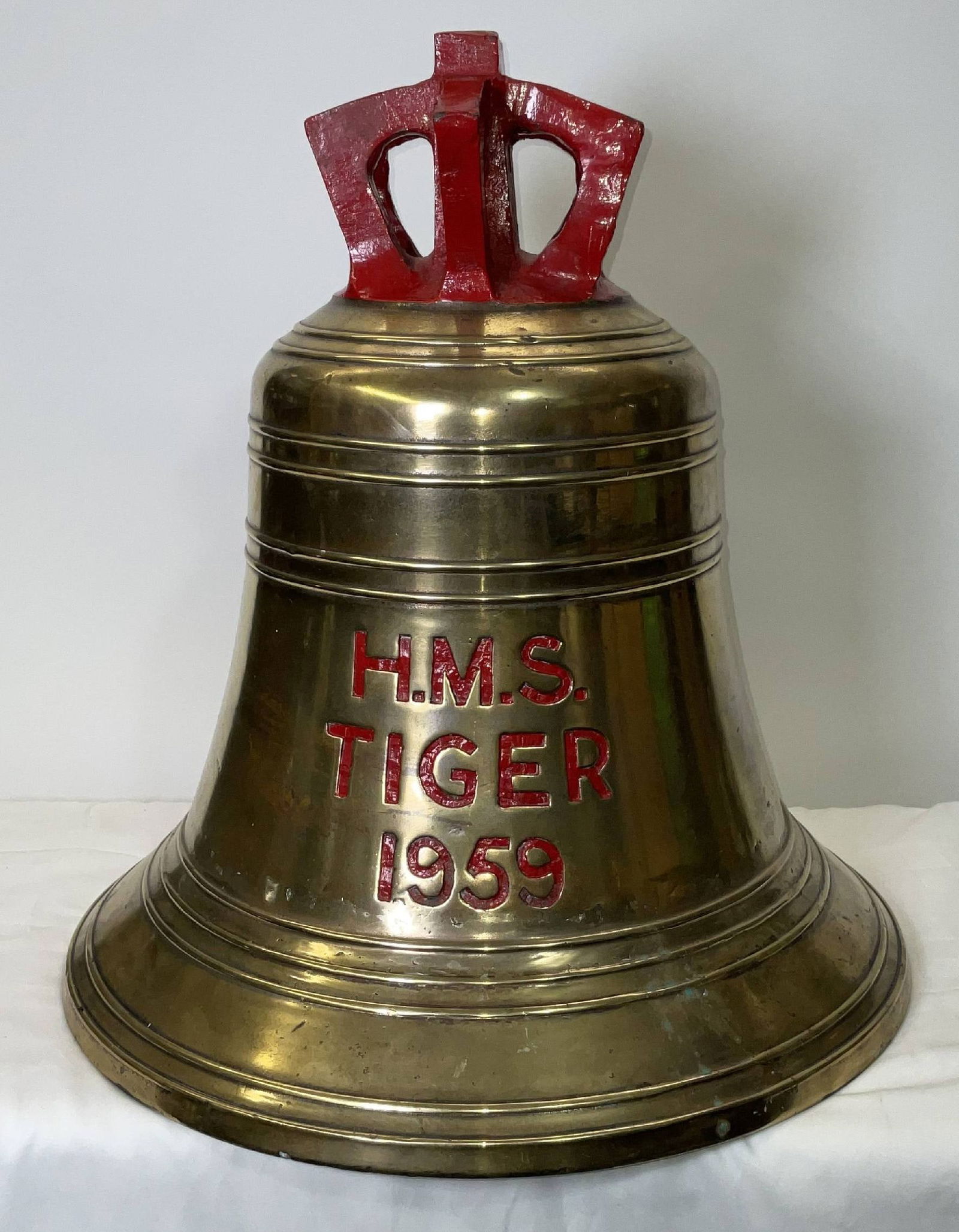 Bell from H.M.S. Tiger (1959): Solid brass bell from the ship H.M.S. Tiger, engraved “H.M.S. Tiger” fitted with a four canon crown mount cast into the bell. H.M.S. Tiger was a Tiger-class guided missile cruiser of the Briti