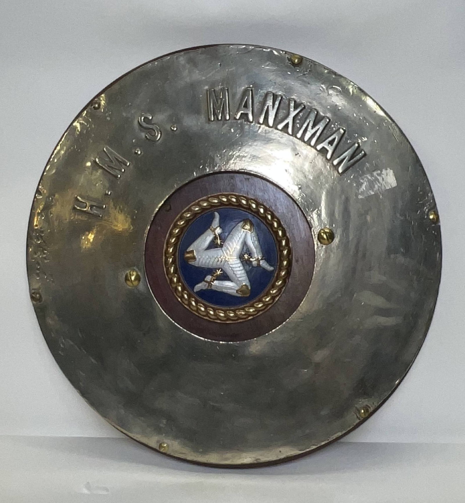 HMS Manxman Ship's Plaque with Ship's Crest: Polished steel screen badge Plaque with Chatham pattern ships crest at center. Wood backplate. HMS Manxman is in raised letters. 26 lbs. 21"Diameter.