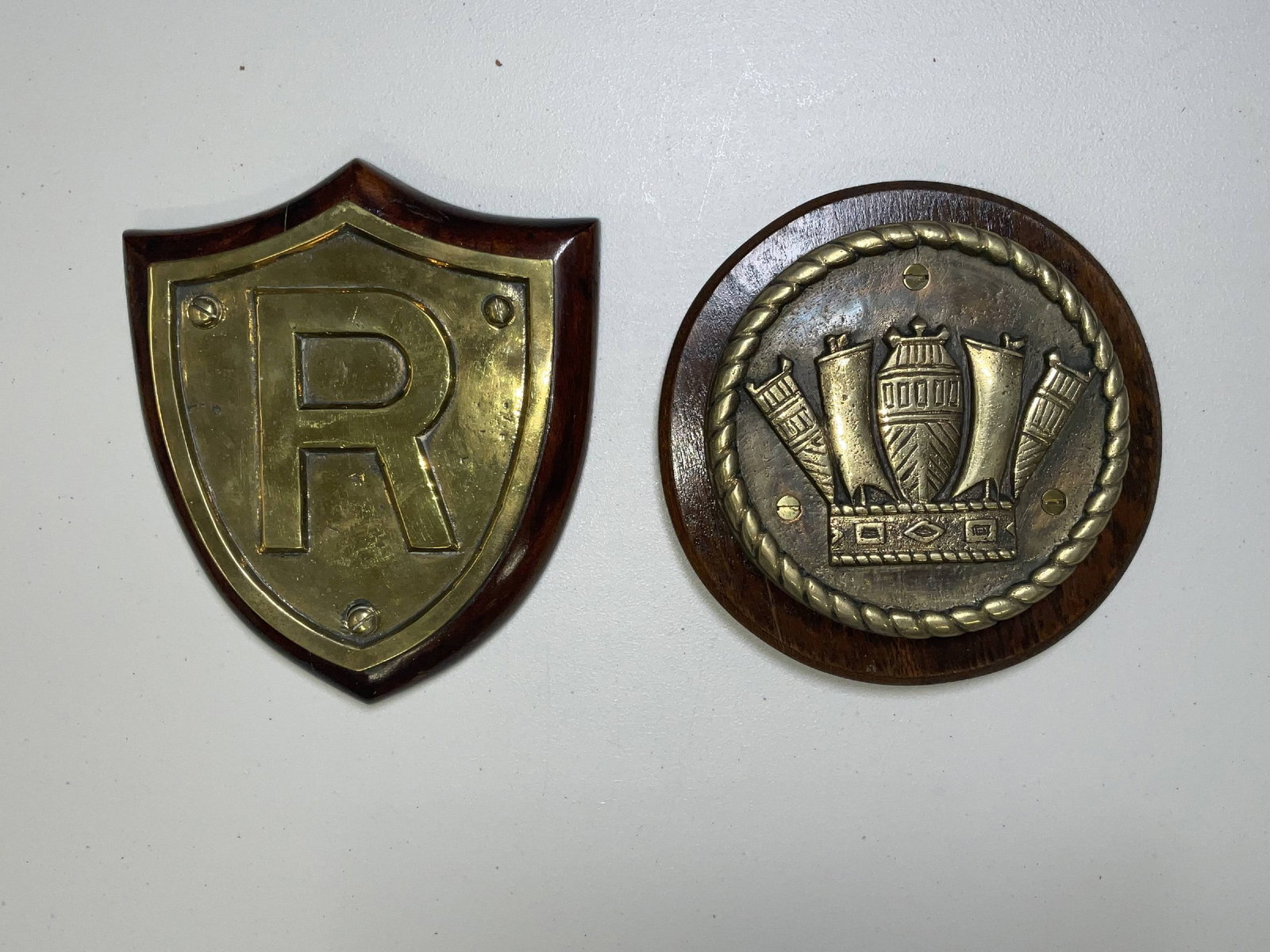 Pair of British Royal Navy Gun Tompions: HMS Relentless of 1924 gun tompion showing a large “R” on a badge. Also, a Royal Navy crown tompion from an unidentified ship. 8 lbs 2 pcs. 9" diameter. 9"H x 8"W.