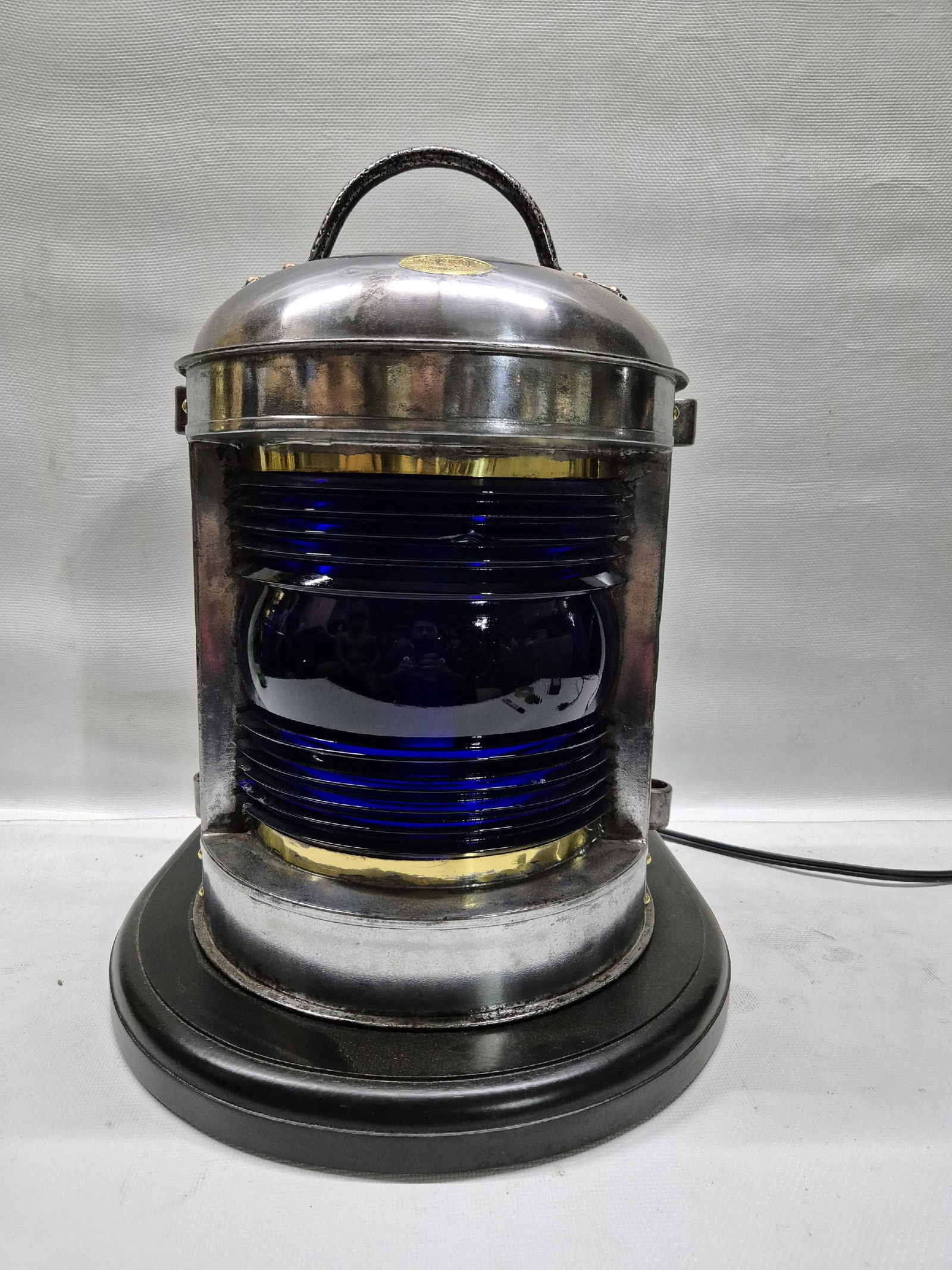 Cobalt Blue Fresnel Lens Perko Ships Lantern: Perko ships lantern with cobalt blue Fresnel lens. Brass makers badge from Perkins Marine Manufacturing of Brooklyn New York. Mounted to a wood base with rope carved border