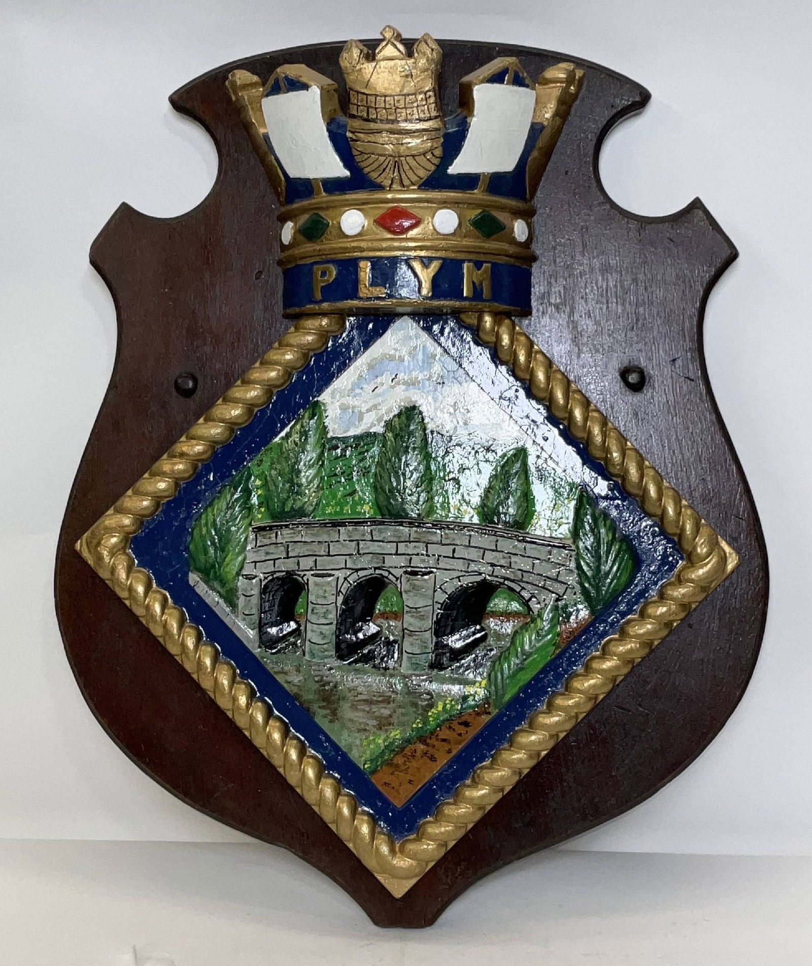 Badge from the British Royal Navy Waship HMS Plymouth: Large carved ships badge from the Royal Navy Rothesay-Class Frigate HMS Pylmouth. She was launched in 1959 and was a museum ship until 1988, then sold for scrap. 8 lbs. 21"H x 17"W.