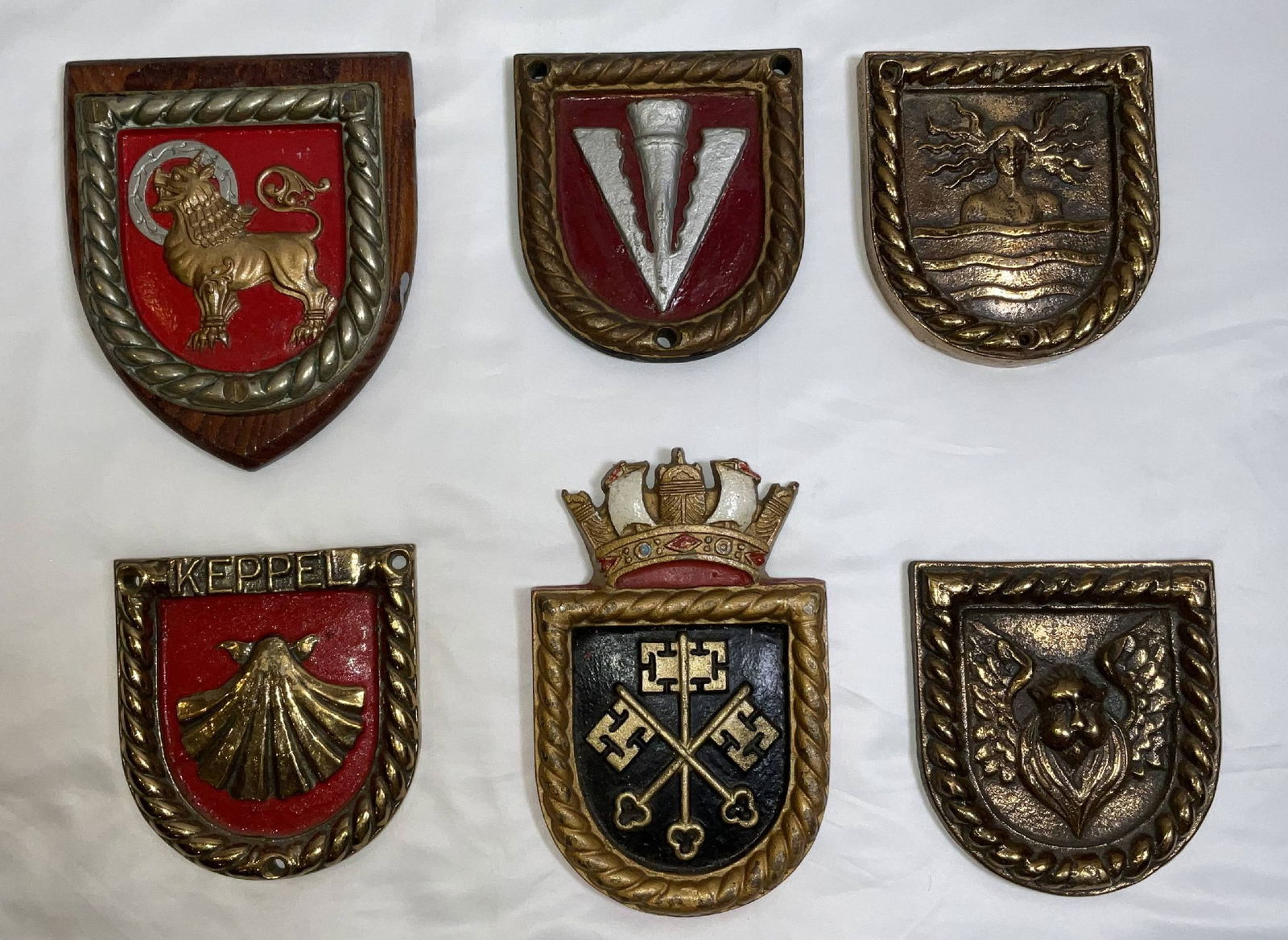 Ship's Badges from British Royal Navy Warships WWI and WWII: Royal Navy ship's badges from HMS Sikh, HMS Wishart, HMS Electra, HMS Keppel, HMS Janus, and HMS Venetia. Rare group of ship's crests. 6 badges. 19 lbs. 7"H x 6"W large. 5"H x 5"W small.
