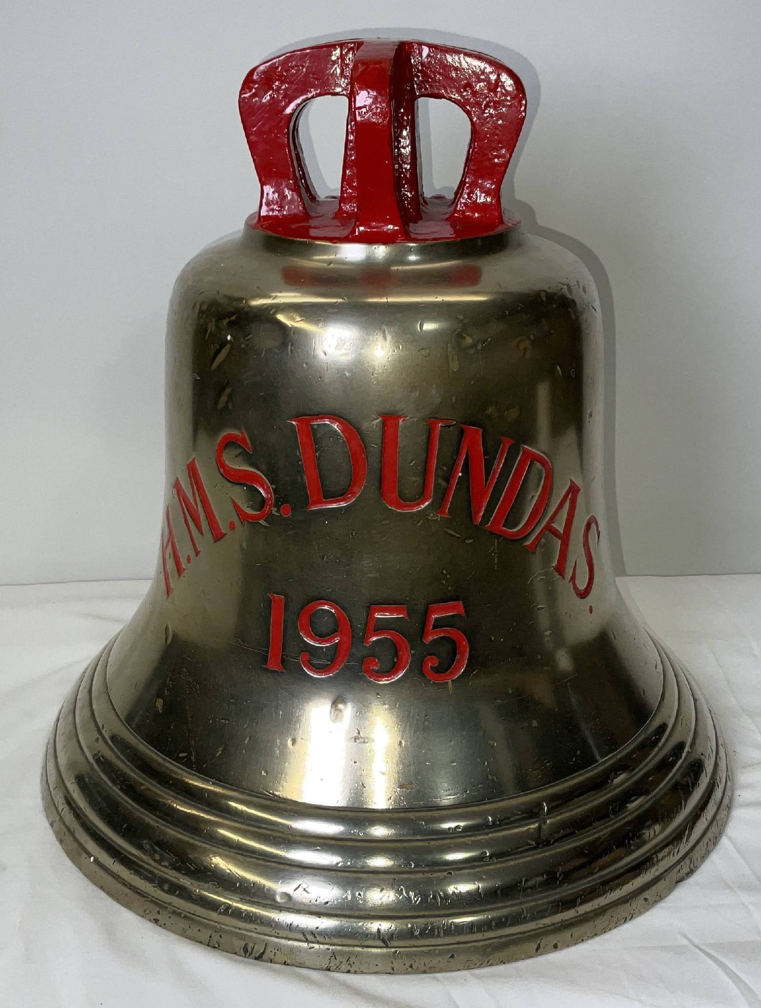 Bell from H.M.S. Dundas, 1955: Solid brass bell from the ship H.M.S. Dundas, engraved “H.M.S. DUNDAS 1955” fitted with a six canon crown mount cast into the bell. H.M.S. Dundas was a Type 14 Blackwood-class anti-submarine f