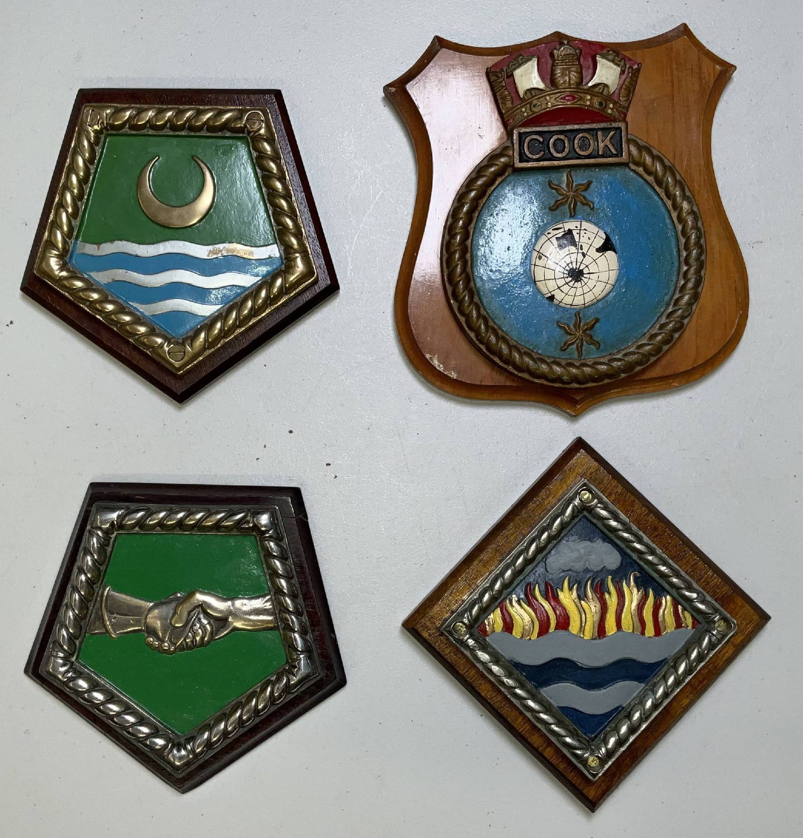 Four British Royal Navy Ship's Chatham Pattern Badges: Group of four solid brass Chatham pattern ship's badges from Royal Navy ships. HMS Concord, HMS Wildfire, HMS Arethusa, and HMS Cook are represented. 20 lbs 4pcs. 10"H x 9"W big. 8"H x 9"W small.