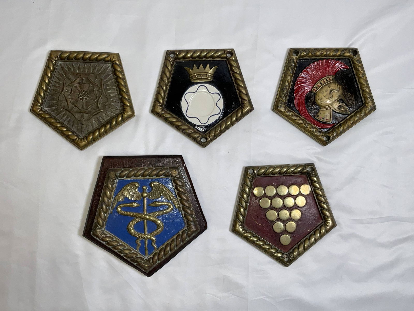 Five Chatham Pattern Ship's Badges from Royal Navy Vessels: Five Chatham pattern Royal Navy ship's badges of ships including HMS York, HMS Lowestoft, HMS Ajax, HMS Despatch, and HMS Cornwall. This is a great lot with interesting designs. 5 badges. 19 lbs. 9"H