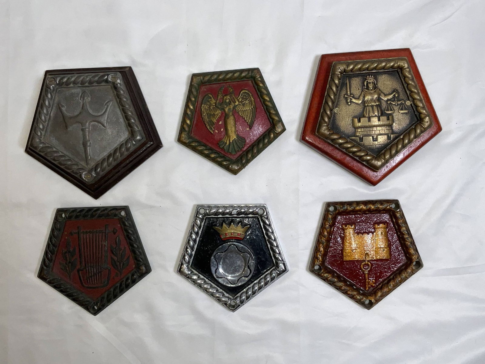 British Royal Navy Chatham Dockyard Pattern Ship's Badges: Quality lot of Royal Navy ship's badges from vessels including HMS Neptune, HMS Victorious, HMS Southampon, HMS Calliope, HMS Lowestoft, and HMS Suffolk, a heavy cruiser. Group of six. 6 badges. 14