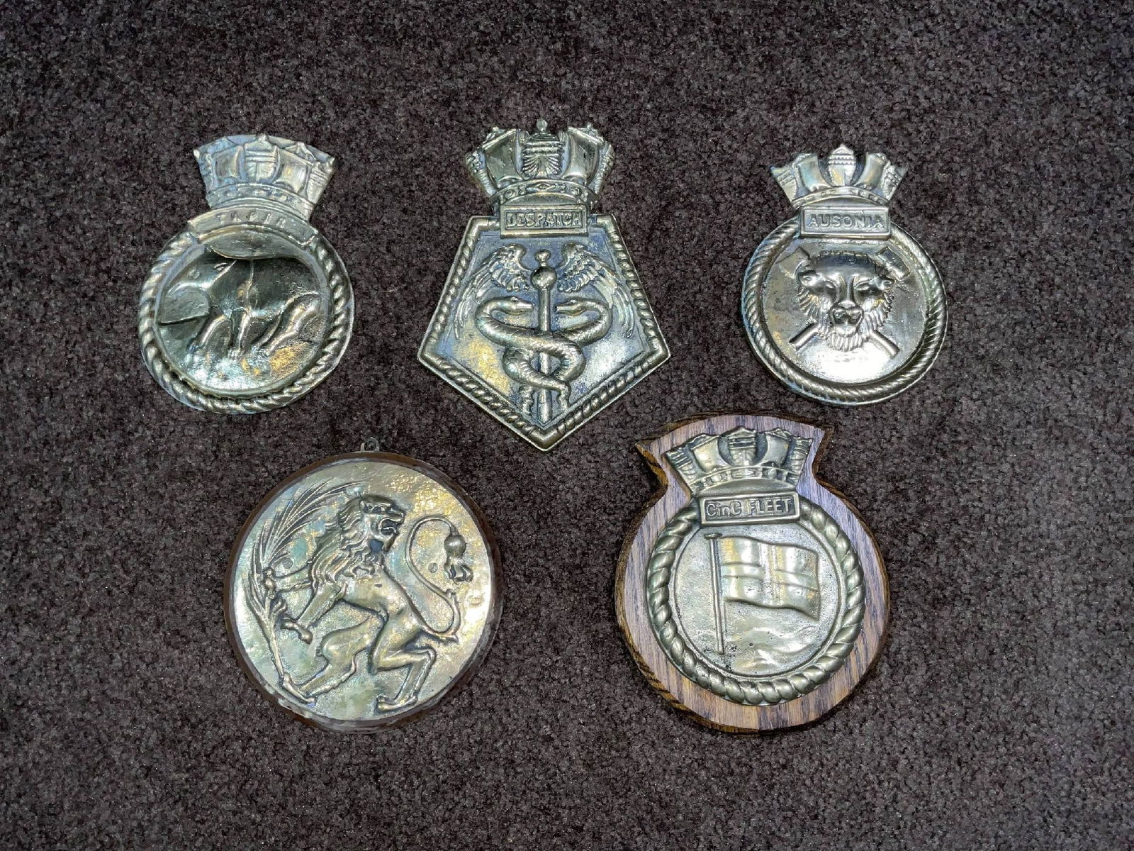 Royal Navy Ship's Badges and Gun Tampion from Submarine and Warships: Heavy brass ship's badges from the submarine HMS Tapir, Light Cruiser HMS Despatch with Normandy, Atlantic and Spartivento battle honors. Also, HMS Ausonia and a C-in-C Fleet badge. There is a gun
