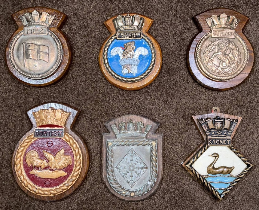 Royal Navy Badges including Three Chatham Pattern: Group of Royal Navy badges including "Flag Officer 2nd Flotilla, Launceston Castle, HMS Jutland, HMS Contest, HMS Talybont, and HMS Cygnet." 24 lbs. 9" H x 7" W (big). 8" H x 6" W (small).