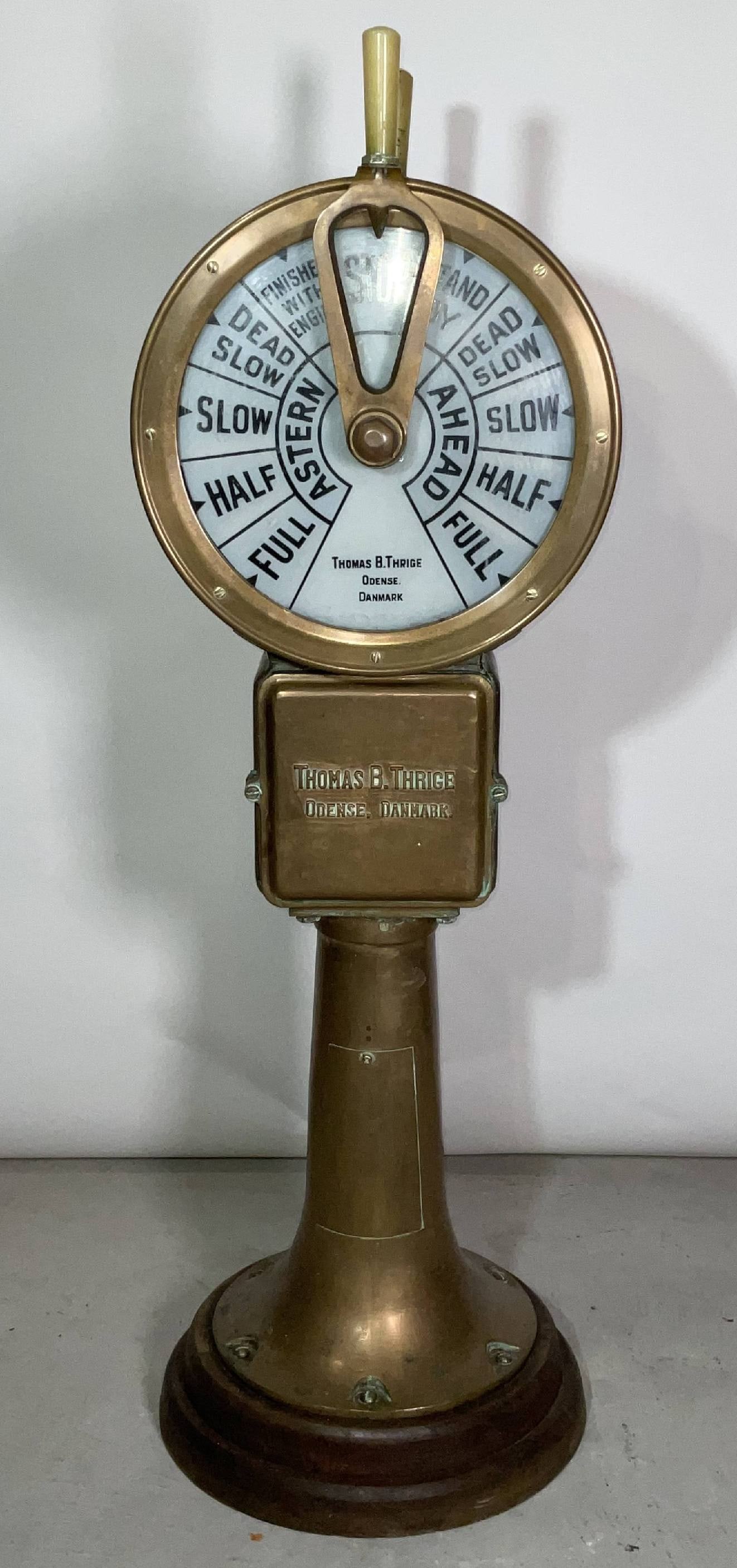 Danish Ship's Telegraph by Thomas Thrige Odense Danmark: Solid brass ship's bridge telegraph with twin face design with ship's commands in English. The maker's name is cast into the base in raised letters, "Thomas B. Thrige, Odense, Danmark". Hard plastic h