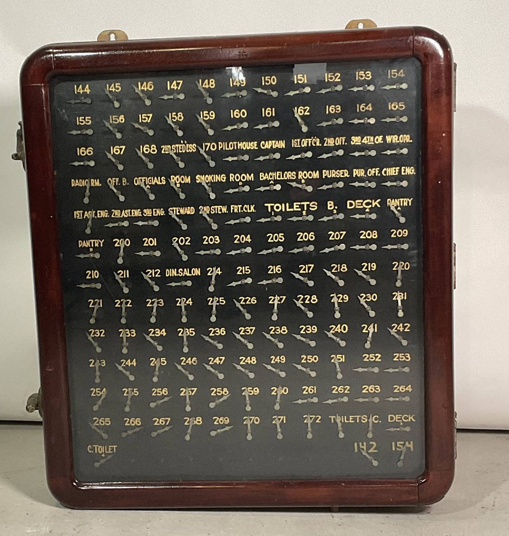 Shipboard Ships Annunciator in Original Case: Ship's annunciator panel. Interesting legend plate showing pilot house, stewards, engineers, radio room, purser, deck, pantry, and over ninety cabins. Varnished wood case. Hinged door with glass.