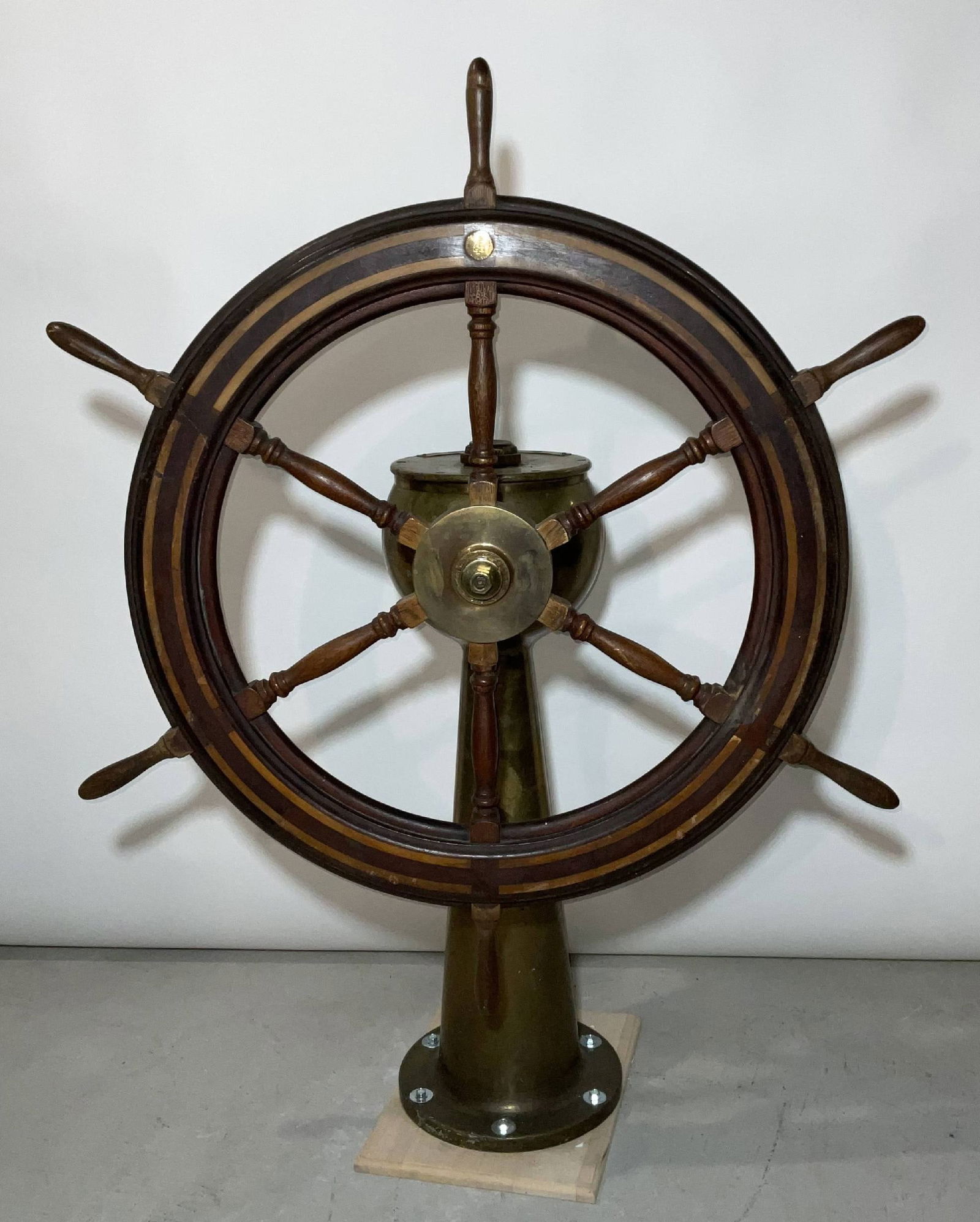American Engineering Company Wheel on Pedestal: Ship's wheel on brass pedestal by American Engineering Company of Philadelphia. The pedestal has a rudder indicator arrow on top. 52"H x 41" Diameter.