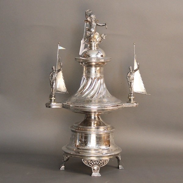 Imposing yachting trophy - Cleveland: Champions trophy from the 1894 & 1895 “Interlakes” Yacht Union Races sponsored by “The Cleveland World” newspaper. Stunning trophy with intricate detail including sailors hoisting flags, a wre