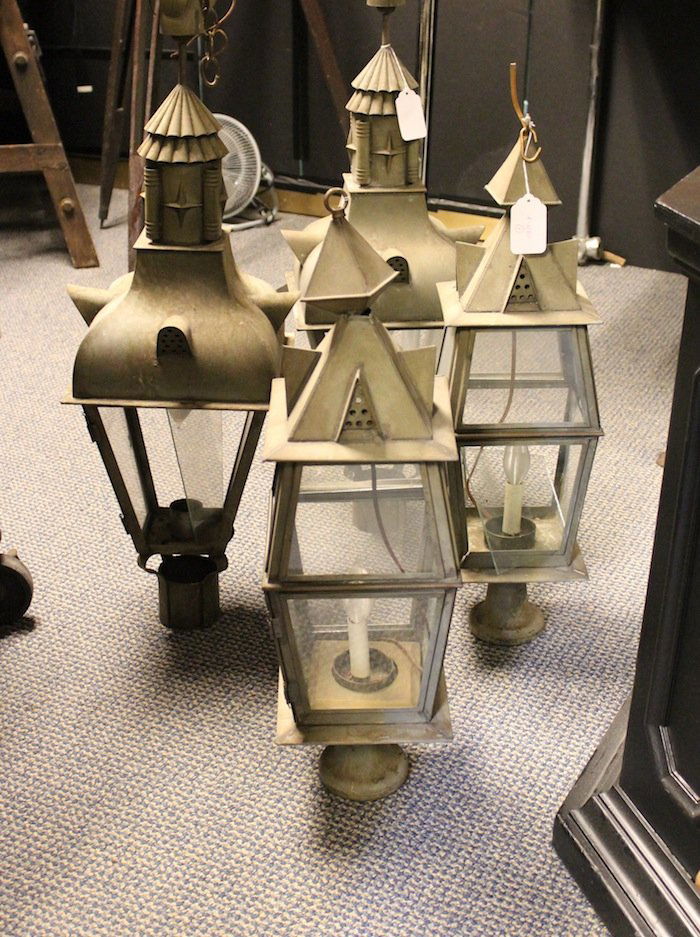 Four metalwork post lanterns: Four metalwork post lanterns from a dining room at Pier4. The fixtures were converted for hanging. Loose and missing glass. 2 @ 26” tall, 2 @ 33” tall.