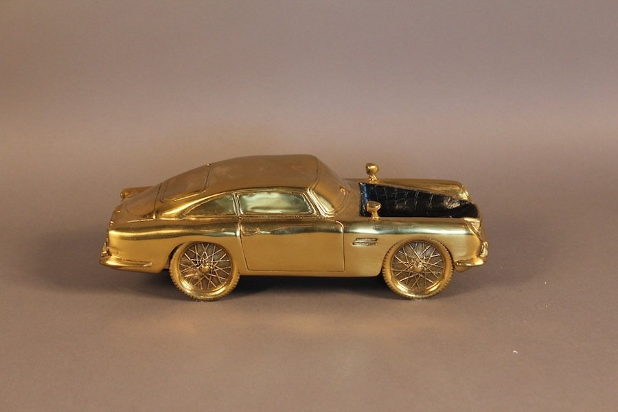Cast Brass Aston Martin Bureau Piece: Solid brass Aston Martin sculpture with area for keys or coins as a sort of bureau accessory. An early Aston DB is the model. First class ornament. 11" long x 4 1/2" wide x 3 1/2" tall