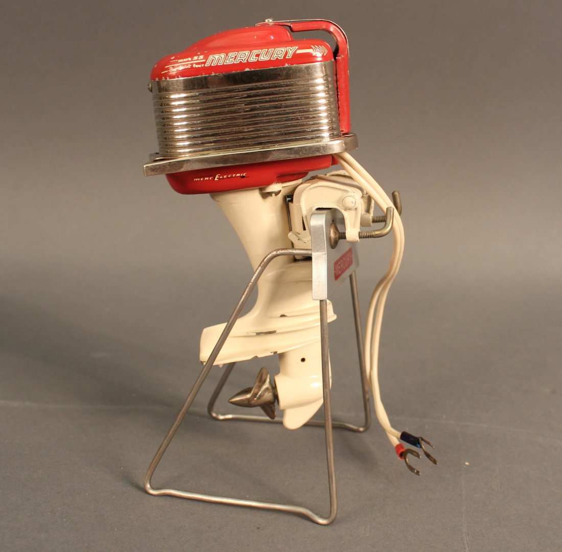 Model of a mercury outboard: Scale electric motor of a 55 horsepower Mercury outboard mounted on a stand in lucite case. Motor 6” tall.
