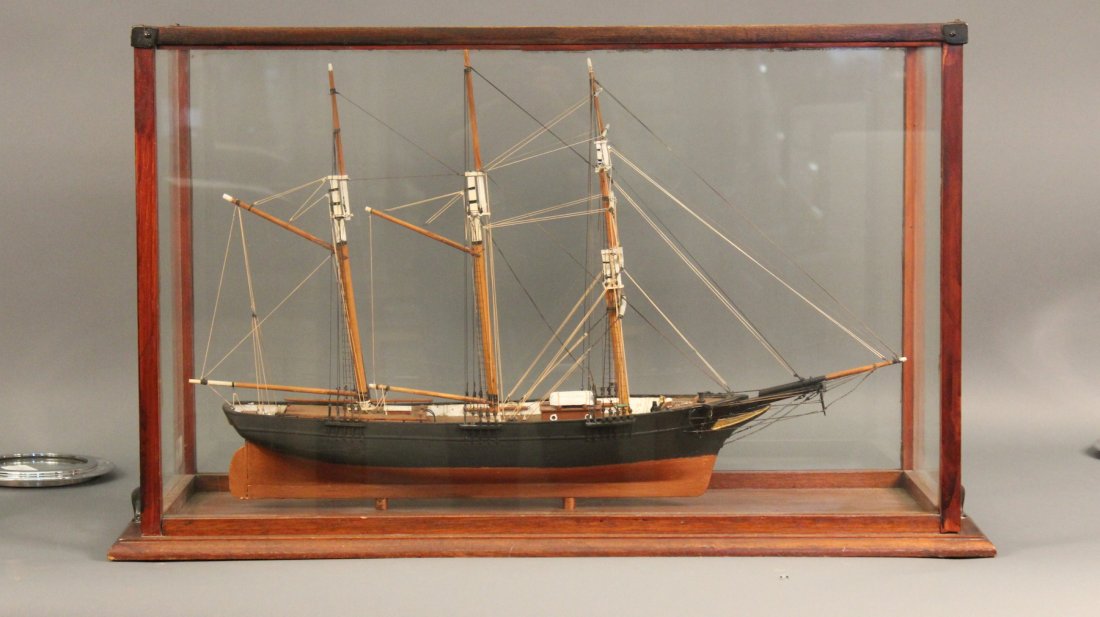 Ship Model of a Barkentine: Three masted barquentine model square rigged on the foremast and forehand at rigged aft. Painted black above and gold below the waterline. Model: 30 x 8 x 18 1/2. Case 35” x 12 1/2” x 21”