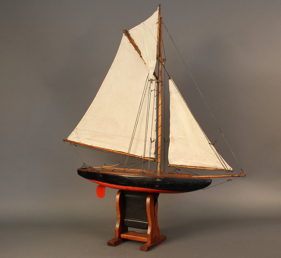 Vintage Pond Yacht of a Sloop: Gaff rigged pond yacht rigged with a suit of three linen sails. Varnished deck with painted hull. Wood cradle. 31" x 6" x 35".