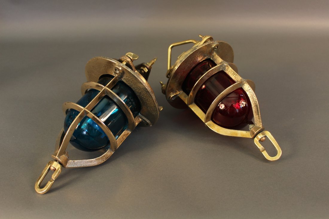 Pair of British Royal Navy Convoy LIghts: Pair of solid brass ship's convoy lights from the English Navy. Dated 1950. One blue lens and one red with heavy protective brass cage. Hoisting bracket and steadying ring. 13 x 8.