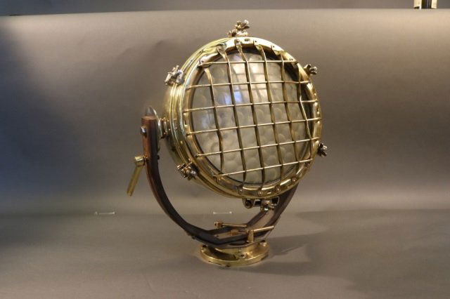 Ship's Cargo Floodlight of Solid Brass: Substantial brass ship's cargo light with glass lens, protective cage, pedestal base, and etc. *This lot is part of a maritime antique auction of ship models, nautical relics, marine paintings, boat p
