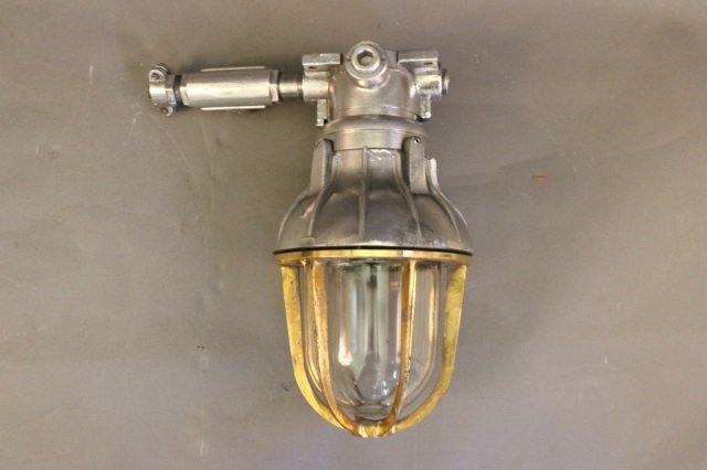 Aluminum and Brass Wall Light: Aluminum and brass wall light with aluminum bracket with brass cage, glass globe and a/c socket. Dimensions: 12" D x 14" D Weight: 13lbs *This lot is part of a maritime antique auction of ship models,