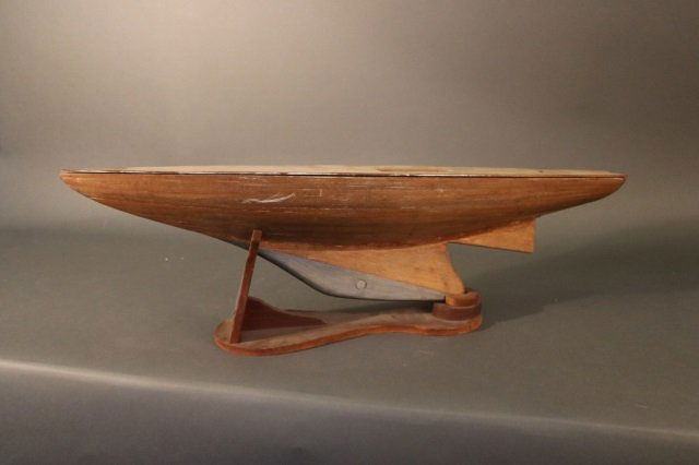 Planked Vintage Pond Yacht Hull: Vintage planked pond yacht hull with lead keel, one piece deck, frames inside the hull. Dimensions: 31" L x 7" W x 9" H Weight: 5lbs *This lot is part of a maritime antique auction of ship models, nau