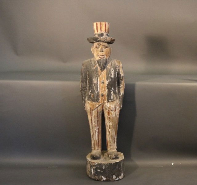 Folk Art Style Uncle Sam: Carved folk art style statue of Uncle Sam, in weathered paint and gesso finish. Dimensions: 13" L x 11" W x 47" H Weight: 22lbs *This lot is part of a maritime antique auction of ship models, nautical