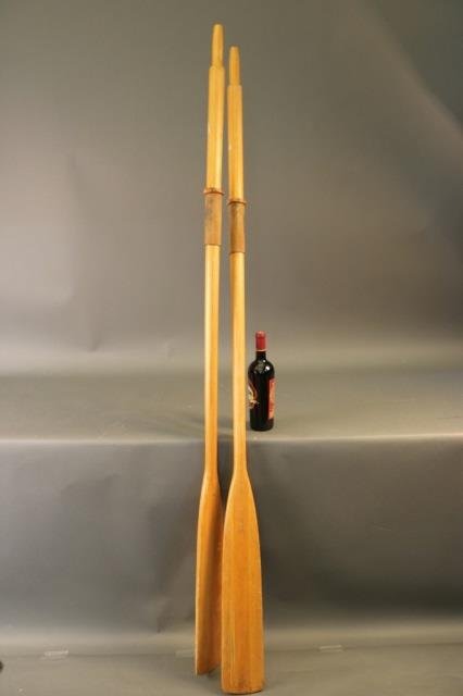 Varnished Pair of Boat Oars: Pair of nautical boat oars with leather collars. Dimensions: 78" L Weight: 6lbs (2 pieces) *This lot is part of a maritime antique auction of ship models, nautical relics, marine paintings, boat parts