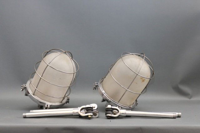 Pair of Industrial Maritime Ship Lights: Ship's cargo lights with glass globes, protective bars, and etc. Dimensions: 10" L x 16" H Weight: 14lbs *This lot is part of a maritime antique auction of ship models, nautical relics, marine paintin