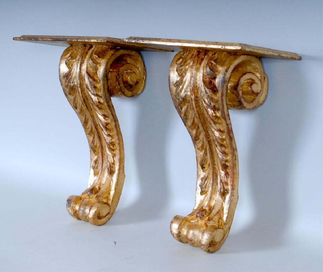 Pr. Italian Neoclassical Giltwood Wall Brackets: 20th century, rectangular top shelf with molded edges supported on scrolled leaf-carved backplates, incised verso "Made in Italy"; 9 3/4"W x 6 1/4"D, 13 1/4"H (Ref. 11-1)