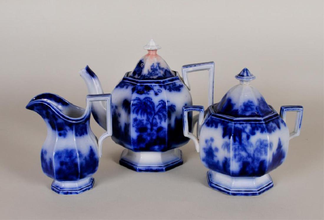 Flow Blue Scinde Pattern Teaset: c. 1840; pumpkin shape; includes 8 1/4"H teapot, 5 1/2"H creamer, 7"H lidded sugar---Teapot marked on base with incised "Oriental / Stone / J. &. G. Alcock" and with blue "Scinde" cartouche; chip to e