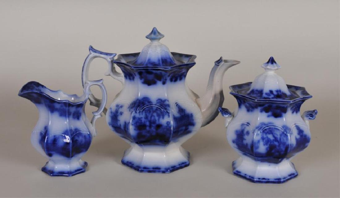 Flow Blue Scinde Pattern Teaset: c. 1840; primary shape; includes 9 1/4"H teapot, 7 1/2"H lidded sugar, 5 3/4"H creamer---Teapot marked on base with incised "Oriental / Stone / J. & G. Alcock" and with blue "Scinde" cartouche; repair