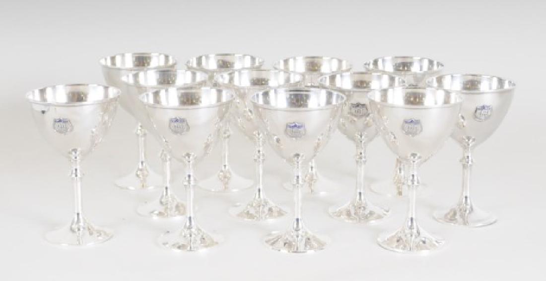 Set of 12 Sterling Martini Stems, Sedlacek & Co.: Each with applied enameled shield to front "Hollywood Country Club", marked on base "Sedlacek & Co. / Sterling / Base Weighted"; 4 1/2"H, 2 7/8" dia.; minor dents, surface scratches