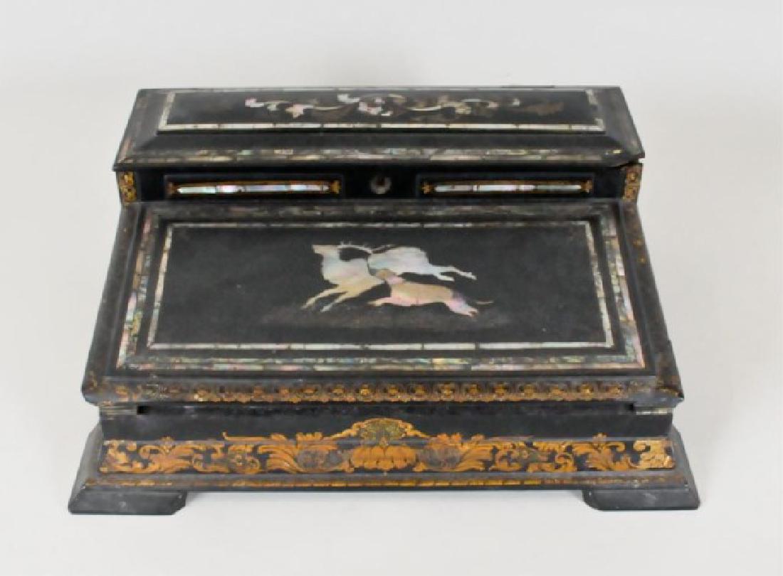 19th C. Papier Mache Inlaid Lap Desk: English black lacquer papier mache lap desk, decorated with mother-of-pearl and abalone inlay, gilt accents, slant top inlaid with stag and hound; fitted interior with pen tray and fold-down velvet wr