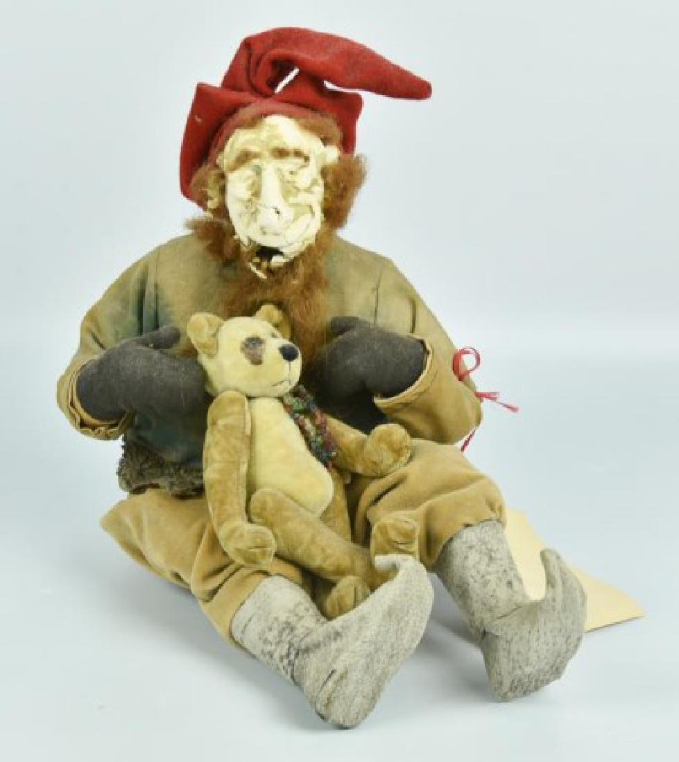 Norma Lizabeth DeCamp (North Carolina, 20th C.): Handcrafted original papier mache elf, seated and holding a teddy bear in his lap, clothing made from antique fabrics, by noted artist Norma DeCamp; original "Norma DeCamp Designs" tag attached having