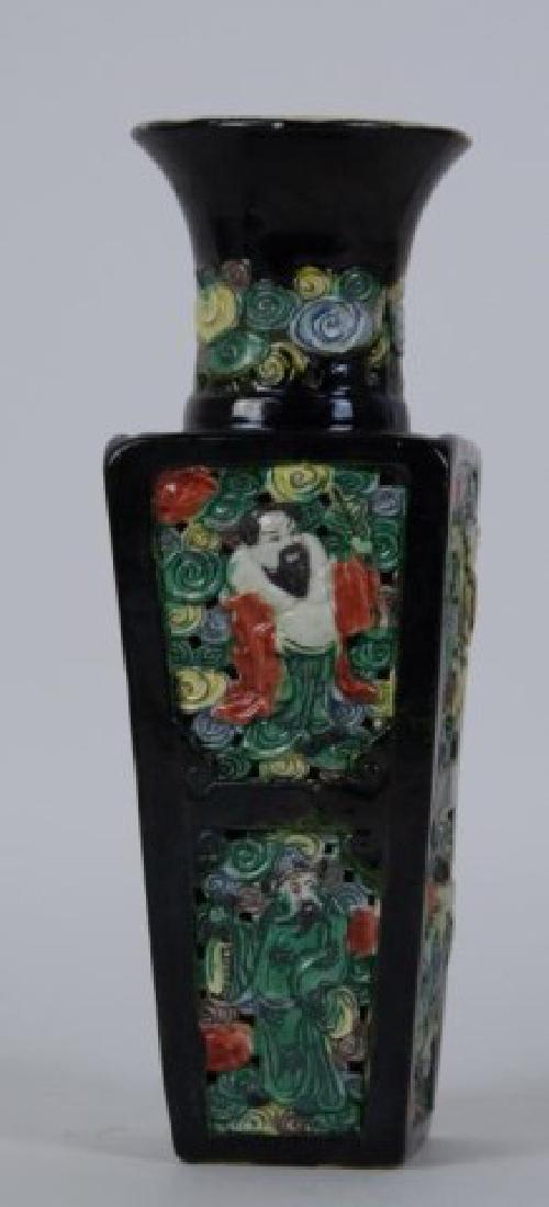 Chinese Famille Noir Reticulated Vase: High shouldered vase with square tapering sides, pierced porcelain body, each side decorated with two panels having a polychrome enameled figure in relief, base marked with faint "CHINA" in red; 9 1/2