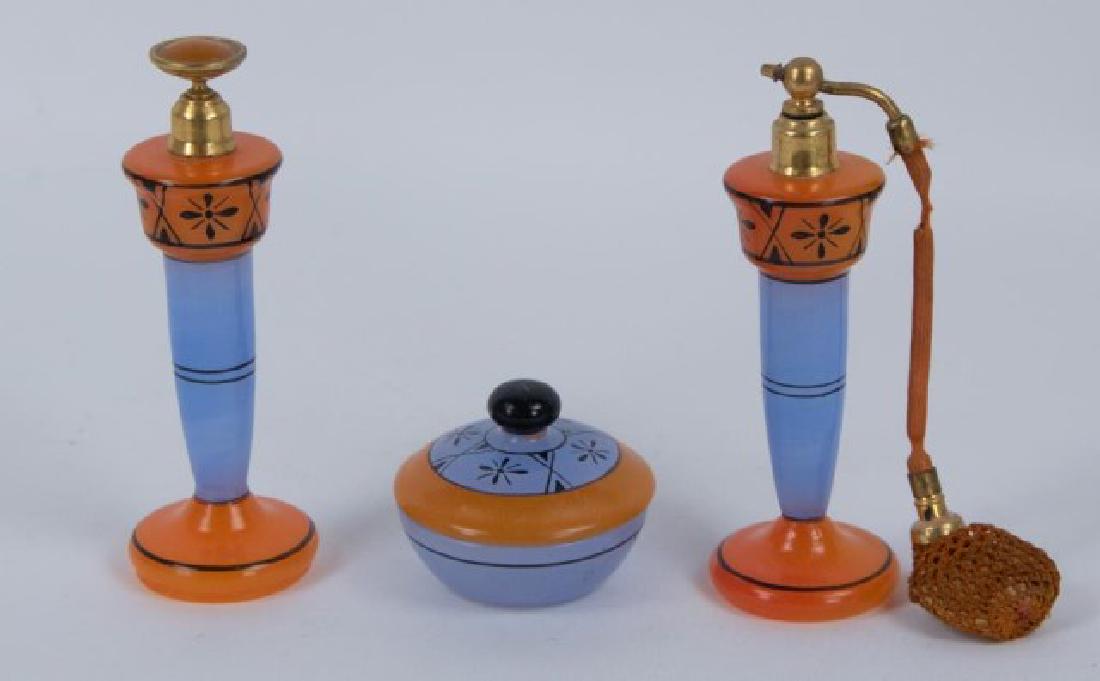 3-Piece Art Deco Czech Glass Dresser Set: Orange and lavender blue or periwinkle with black striping and geometric and floral accents; set includes 6 1/8"H perfume with dauber, 6"H atomizer having bulb covered with crocheted netting and 2 7/8
