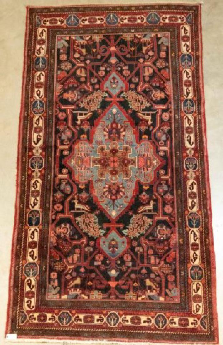 Elaborate Persian Rug; 5'5"W x 10'4"L: Complex central panel with animals, flowers and geometrics on a navy ground surrounding a slate blue central medallion with flowers and other designs in red, brown, coral, ivory and green; seven borde