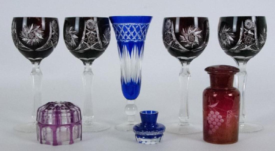 Lot of Cut to Clear Crystal: Eight total items: 1. Set of four ruby cut to clear wine glasses, hobstar and pinwheel motif, clear faceted stem; mid 20th century; 7 1/2"H---2. Cobalt cut to clear vase, flared rim, paneled sides; 7 