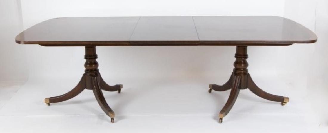 George III Style Henredon Mahogany Dining Table: Banded rectangular top with rounded corners and one 20" leaf, set on double pedestals, each with a turned baluster form standard and three molded legs terminating in brass caps and casters, includes p