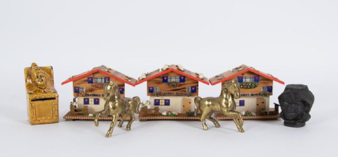 Lot of Seven Still Banks: Includes: Two brass horse banks; 4 1/2"L, 4"H---Pottery "Jack-in-the-Box" bank; 4 3/4"H, 2 3/8"W, 2 1/8"D; small chips to edges---Cast iron "Two Faces Black Boy" bank; 3 1/8"H---Three wooden cottage b