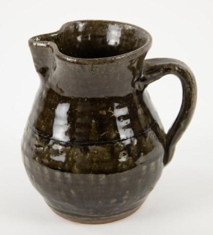 Lanier Meaders Stoneware Pitcher: White County, Georgia, 1917-1998; runny green alkaline glazed pitcher, incised line at shoulder, pinched rim and spout, applied strap handle, signed on base "Lanier Meaders 1991"; 6 1/4"H; good condit