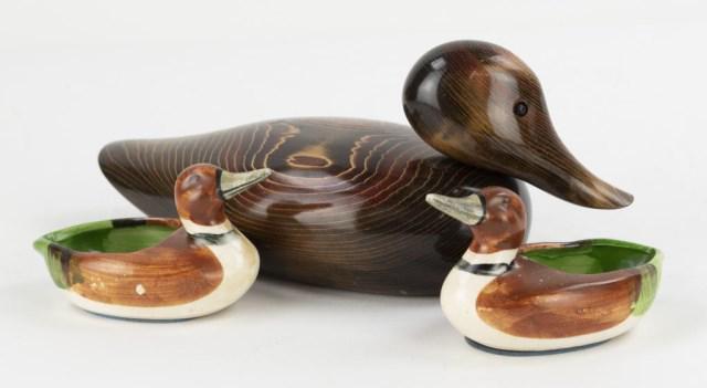 John Bundy Wood Duck Decoy & Duck Trinket Dishes: 1. Wooden duck decoy, marked on bottom "Bundy & Company / John E. Bundy / Made in U.S.A."; 9 1/4"L, 3 7/8"H; good condition overall with flea bites to edge of beak and tail---2. Pair of mid century ce